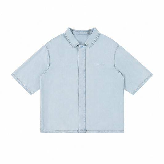 A light blue short-sleeve button-up shirt with a pointed collar and a small embroidered logo on the left chest, displayed flat against a solid white background.